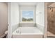 Clean bathroom features tub, shower, tile surround, and a window with a view at 2023 Wyndham Pl, Conyers, GA 30013