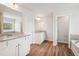 Modern bathroom featuring double vanities, wood-look floors, and a separate shower and tub at 2023 Wyndham Pl, Conyers, GA 30013
