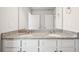 Dual sink bathroom vanity with white cabinets and gray granite countertops at 2023 Wyndham Pl, Conyers, GA 30013