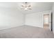 A spacious bedroom features plush carpeting, a ceiling fan, and an open doorway at 2023 Wyndham Pl, Conyers, GA 30013