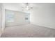 Spacious bedroom with neutral carpet, ceiling fan, and bright natural light from two windows at 2023 Wyndham Pl, Conyers, GA 30013