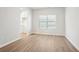 Living room area featuring wood-look flooring, a window for natural light, and a glimpse of the kitchen at 2023 Wyndham Pl, Conyers, GA 30013