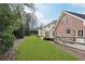 Landscaped backyard with lush green lawn, mature trees, wooden fence and brick exterior of the house at 5275 Redfield Ct, Atlanta, GA 30338