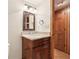 Vanity with granite countertop, dark wood cabinets, mirror, and fixtures in cozy bathroom at 5275 Redfield Ct, Atlanta, GA 30338
