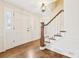 Bright foyer featuring hardwood floors, a staircase, and a paneled front door at 5275 Redfield Ct, Atlanta, GA 30338