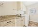 Well-lit laundry room with granite countertops and modern washer and dryer for efficient chores at 5275 Redfield Ct, Atlanta, GA 30338