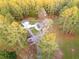 An aerial view of a house in a wooded area with a detached garage and several vehicles in the driveway at 935 Old Loganville Rd, Loganville, GA 30052