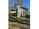 View of the back of the house featuring a large chimney and screened-in porch at 1677 Grey Fox Ct, Lawrenceville, GA 30044