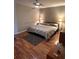 Bedroom featuring a queen-sized bed, wood floors, bedside tables, and accent lamps at 1677 Grey Fox Ct, Lawrenceville, GA 30044