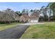 Spacious home with a three-car garage, stone accents, well-manicured lawn, mature trees, and a paved driveway at 181 Pinehurst Ln, Marietta, GA 30068
