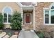 Inviting front entrance with stone accents, a red door, a small porch, and meticulously landscaped garden beds at 181 Pinehurst Ln, Marietta, GA 30068