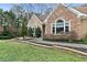 Charming home with stone exterior, arched windows, mature landscaping, a walkway, and a well-maintained lawn at 181 Pinehurst Ln, Marietta, GA 30068