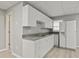 Well-lit kitchen featuring white cabinets, grey countertops, stainless sink, and refrigerator at 181 Pinehurst Ln, Marietta, GA 30068