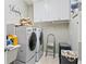 Efficient laundry room with modern washer and dryer, overhead cabinets, and sink at 181 Pinehurst Ln, Marietta, GA 30068