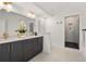 Modern bathroom featuring double sinks with gold hardware, tiled floors, and a glass-enclosed shower at 1836 Memorial Dr # 303, Atlanta, GA 30317