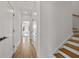 Hallway with wood floors, white walls, staircase, and modern black door hardware at 1836 Memorial Dr # 303, Atlanta, GA 30317