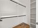 Neat walk-in closet with custom shelves and rods on wood floors at 1836 Memorial Dr # 303, Atlanta, GA 30317