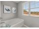 Bright bathroom featuring a tub with chrome fixtures, window, and light-colored walls at 3071 Greyton Dr, Buford, GA 30519