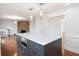 Modern kitchen with a gray island, marble countertops, stainless microwave, and hardwood floors at 1986 Willeo Creek Pt, Marietta, GA 30068