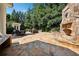 Extensive stone patio featuring a fireplace, dining and lounge area, with manicured lawn at 2225 Johnson Ferry Rd., Marietta, GA 30062
