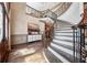 Grand foyer with a curved staircase, hardwood floors, and elegant console table at 2225 Johnson Ferry Rd., Marietta, GA 30062