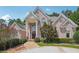 Brick home with stately columns at front door, trimmed shrubs, and circular driveway at 2225 Johnson Ferry Rd., Marietta, GA 30062