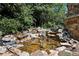 Backyard with cascading water feature surrounded by natural rock and lush landscaping at 2225 Johnson Ferry Rd., Marietta, GA 30062
