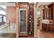Convenient wine cellar with a cooler and wine racks, nestled in the hallway and decorated with wood accents at 2225 Johnson Ferry Rd., Marietta, GA 30062