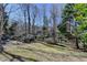 Spacious backyard featuring a gentle slope with mature trees in the background at 1301 Dayspring Trce, Lawrenceville, GA 30045