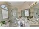 Bright bathroom with tiled glass shower, large mirror, vanity with sink, and an arched window at 1301 Dayspring Trce, Lawrenceville, GA 30045