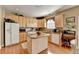 Kitchen featuring light wood cabinetry, granite countertops, and center island with breakfast bar at 1301 Dayspring Trce, Lawrenceville, GA 30045