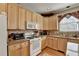Bright kitchen featuring light wood cabinets, granite countertops, and updated appliances at 1301 Dayspring Trce, Lawrenceville, GA 30045