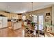 Eat-in kitchen with central island, hardwood floors, light wood cabinetry, and bright lighting at 1301 Dayspring Trce, Lawrenceville, GA 30045