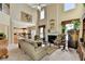 Spacious living room with a fireplace, tall windows, and an open view of the kitchen and dining area at 1301 Dayspring Trce, Lawrenceville, GA 30045
