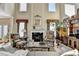 Elegant living room featuring a fireplace, high ceilings, and large windows for natural light at 1301 Dayspring Trce, Lawrenceville, GA 30045