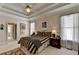 Comfortable bedroom with a tray ceiling, large windows, and neutral paint at 1301 Dayspring Trce, Lawrenceville, GA 30045