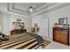 Spacious main bedroom featuring a decorative tray ceiling with ceiling fan and classic wood furniture at 1301 Dayspring Trce, Lawrenceville, GA 30045