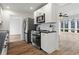 Open-concept kitchen with stainless steel appliances, white cabinetry, hardwood floors, and views of the sunroom at 1760 Canton Hills Cir, Marietta, GA 30062