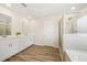 Bright bathroom features a double vanity, wood-look floors, and a separate glass shower at 1761 Dosk Ave, Lawrenceville, GA 30044