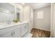 Elegant bathroom featuring double sinks, wood-look flooring, and a bright window for natural light at 1761 Dosk Ave, Lawrenceville, GA 30044