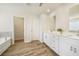 Well-lit primary bathroom features double vanity, white cabinets, and a separate tub and walk-in shower at 1761 Dosk Ave, Lawrenceville, GA 30044