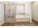 Modern bathroom features a tiled shower, soaking tub and wood look floors at 1761 Dosk Ave, Lawrenceville, GA 30044