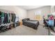 Bedroom with a bed, desk, and clothing rack, showing a carpeted floor and natural light at 1761 Dosk Ave, Lawrenceville, GA 30044