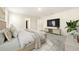 A bright and airy bedroom featuring neutral decor, carpeted floors and an entertainment center with mounted television at 1761 Dosk Ave, Lawrenceville, GA 30044