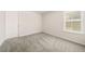 Bedroom with a window, neutral-toned walls, and soft carpeting, offering a blank canvas for personalization at 1761 Dosk Ave, Lawrenceville, GA 30044