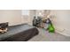 Bedroom with a bed, desk, and carpeted floor, showcasing a comfortable living space with natural light at 1761 Dosk Ave, Lawrenceville, GA 30044