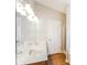 Bathroom with double sink, bright lighting, and wood look floors at 603 Stonecrest Dr, Loganville, GA 30052