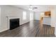 Spacious living room with modern flooring, a fireplace, and access to the kitchen and backyard at 603 Stonecrest Dr, Loganville, GA 30052