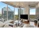 Airy living room featuring floor-to-ceiling windows offering city views, hardwood floors, and a modern chandelier at 860 Peachtree Ne St # 2001, Atlanta, GA 30308