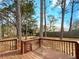 Beautiful backyard featuring a wooden deck, mature trees, and fenced perimeter at 10839 Mallard Dr, Jonesboro, GA 30238